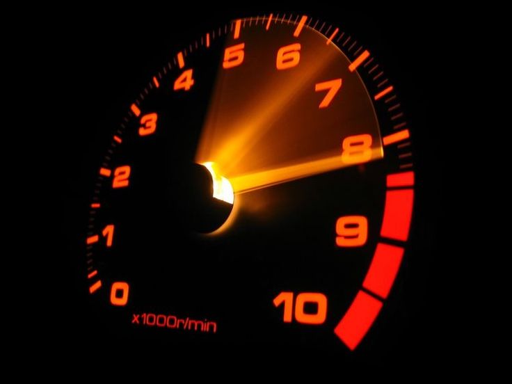 Glowing orange tachometer close-up showing engine RPM markings